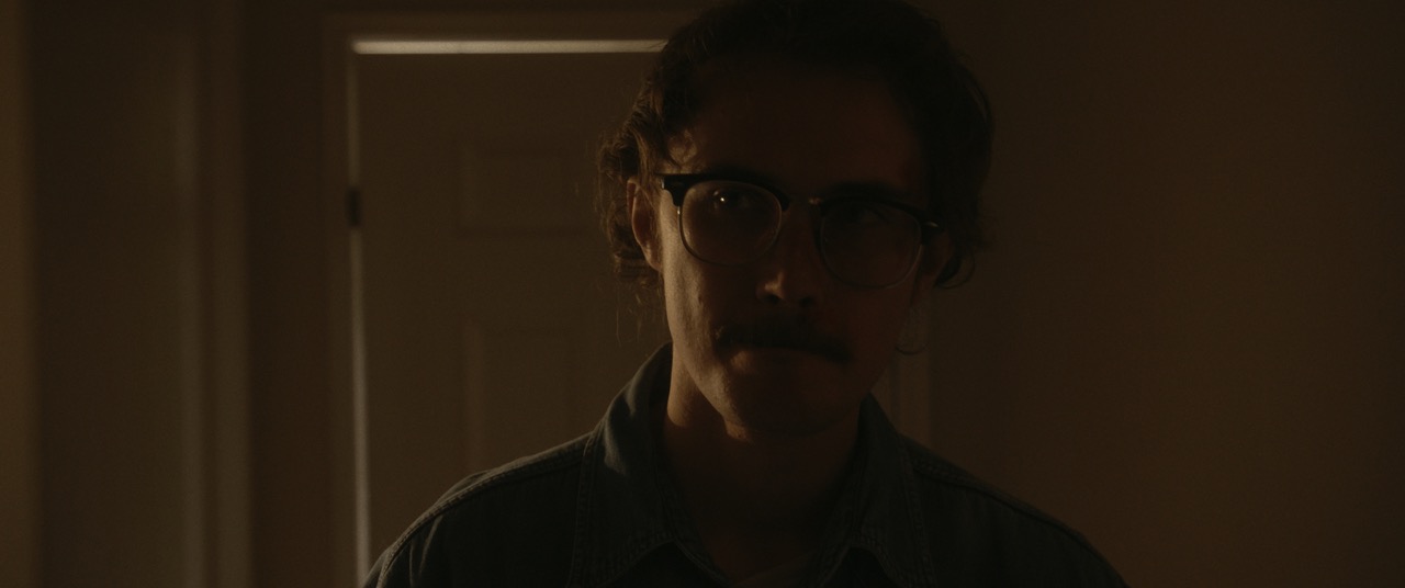 a man looks sorrowful in a dark room