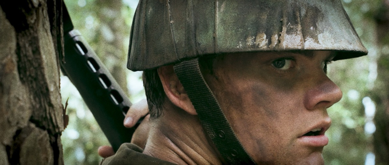 a man in a war uniform looks over his shoulder