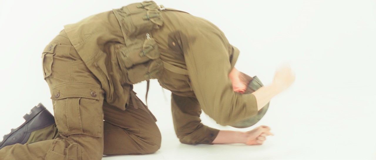 a man in a war uniform bangs on the ground in a white void