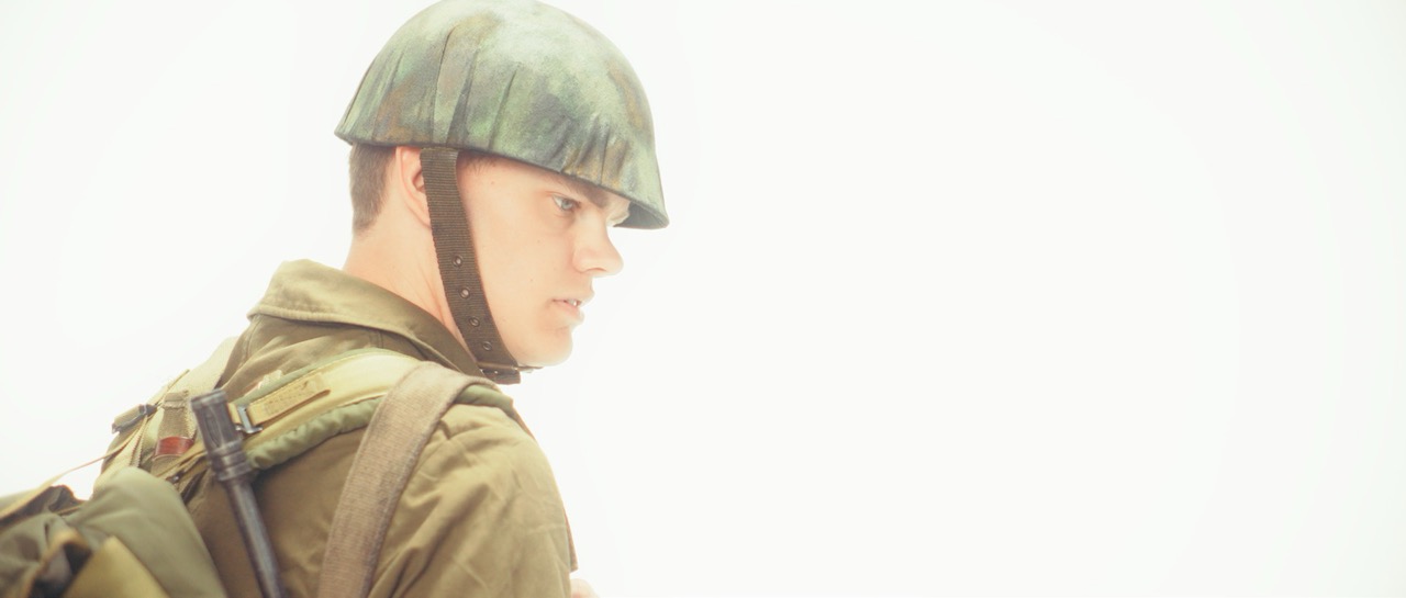 a man in a war uniform stands in a white void