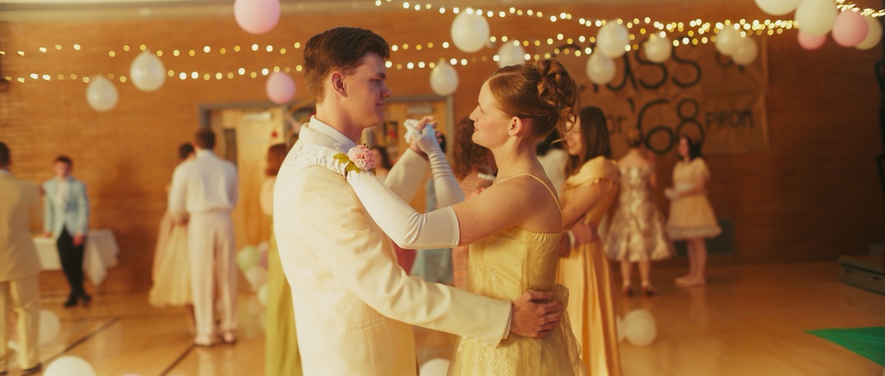 a man and a woman dance in prom attire
