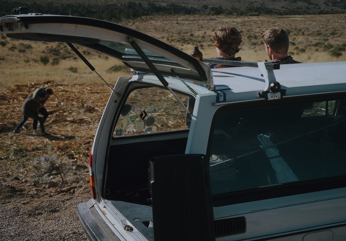 the trunk of a station wagon is open on the side of the road