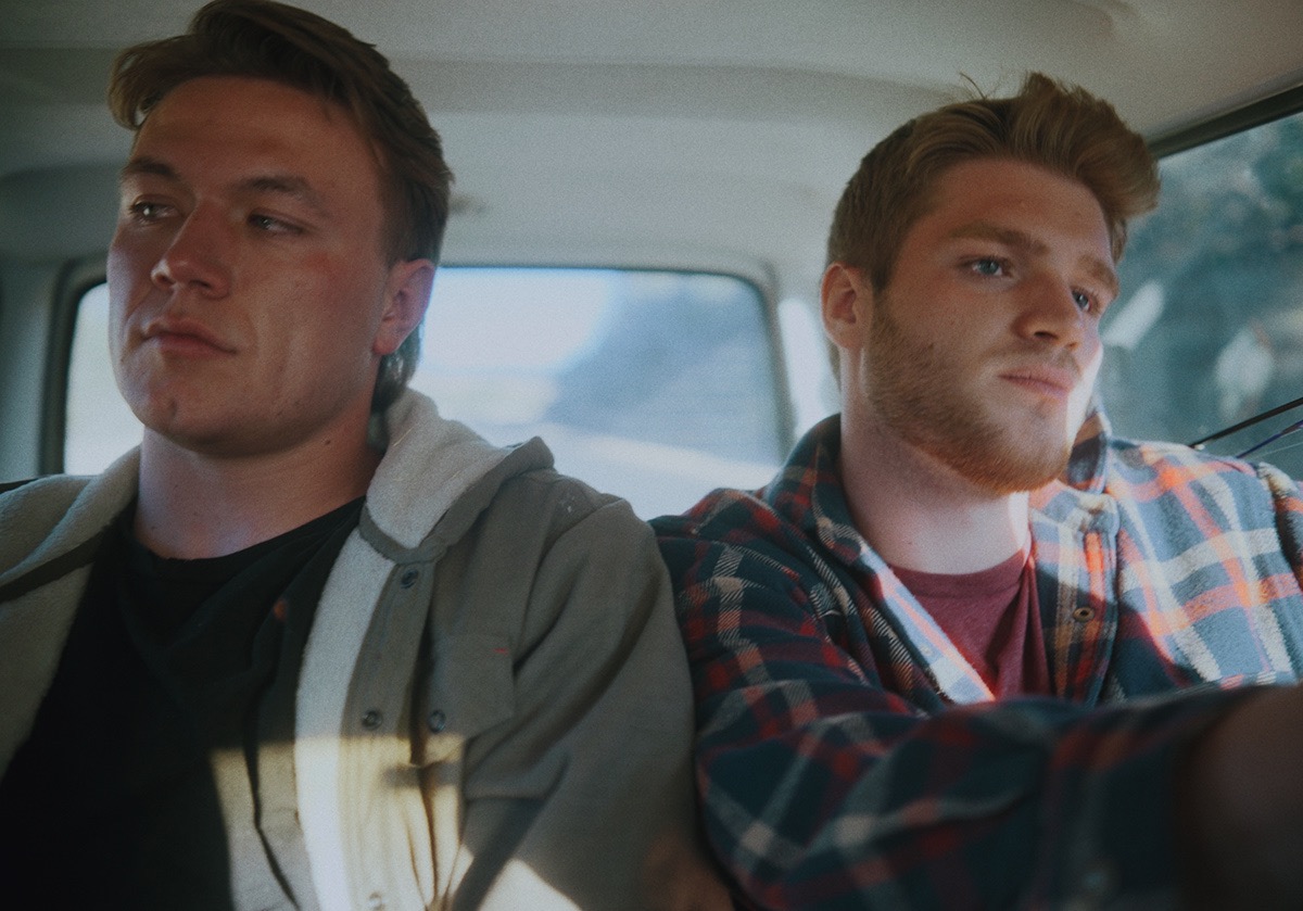 two boys sit cramped in a car