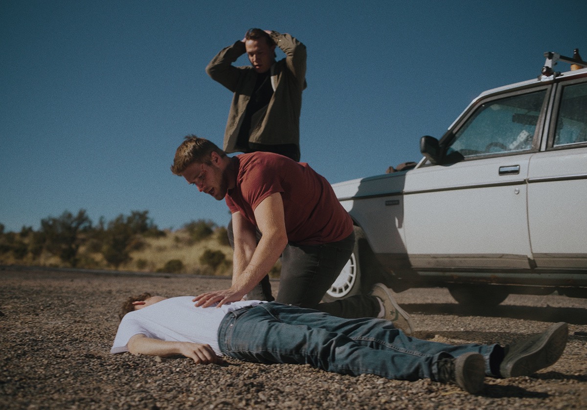 two boys look in shock as they check the body of another boy