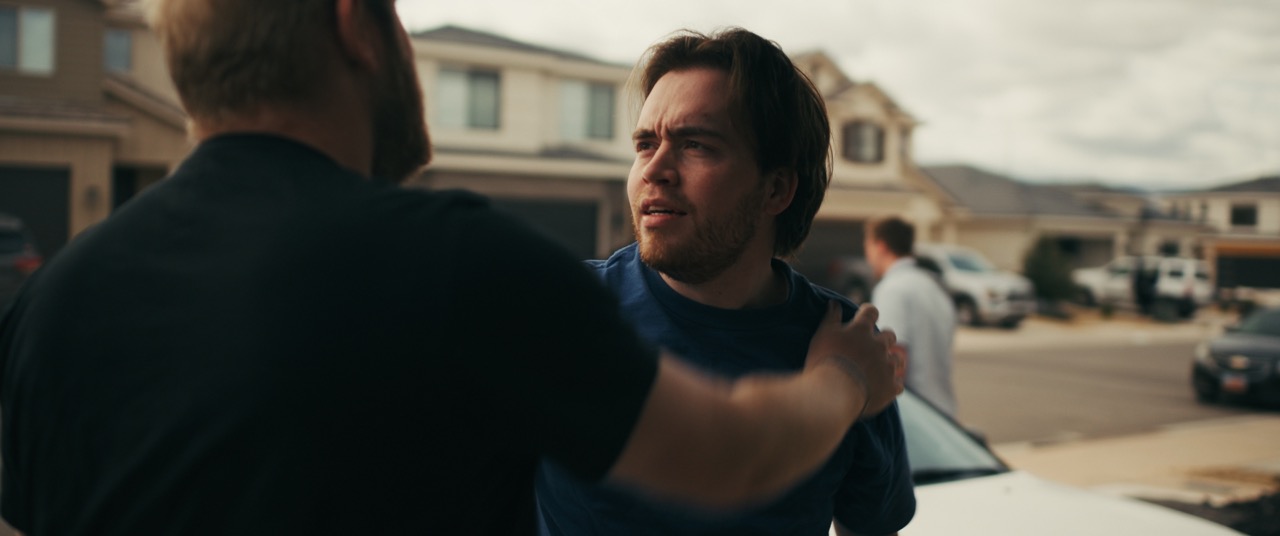 a man assures another man in a garage