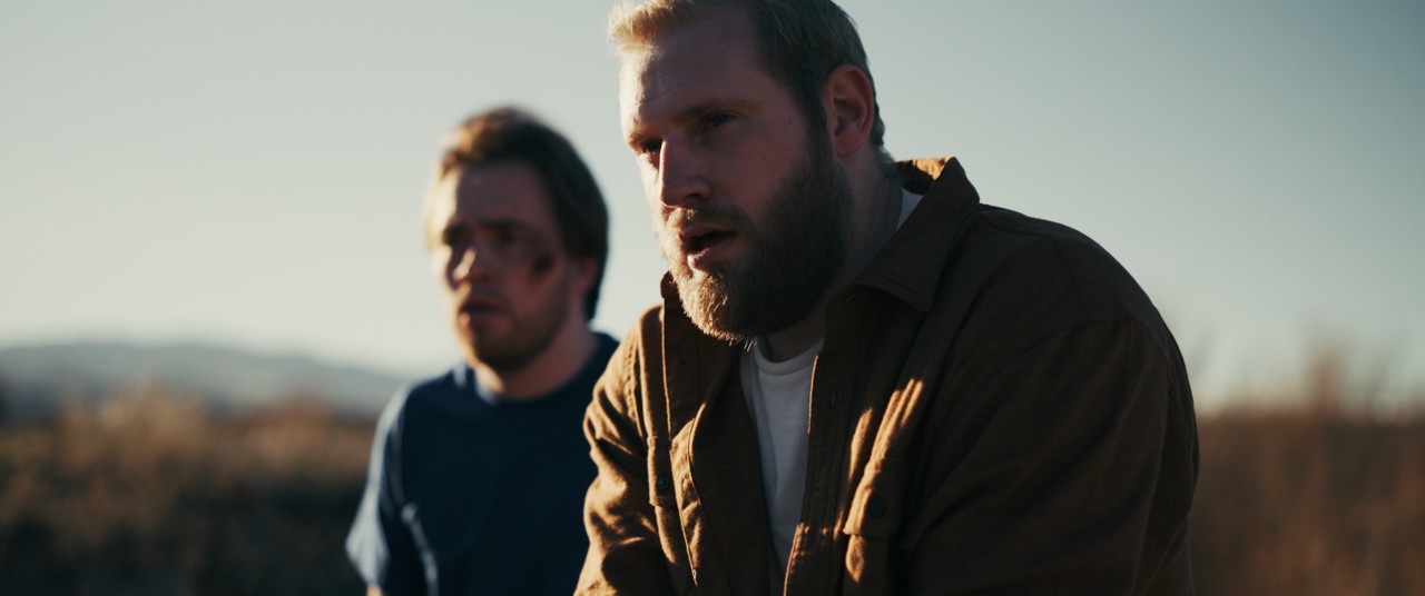 two men look at the horizon in a hot desert