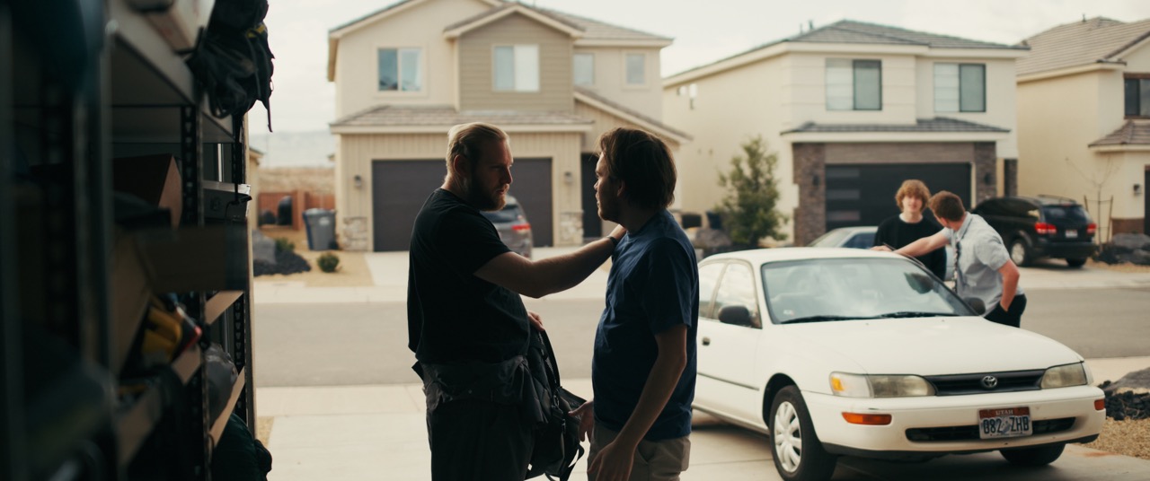 two men greet each other in a garage