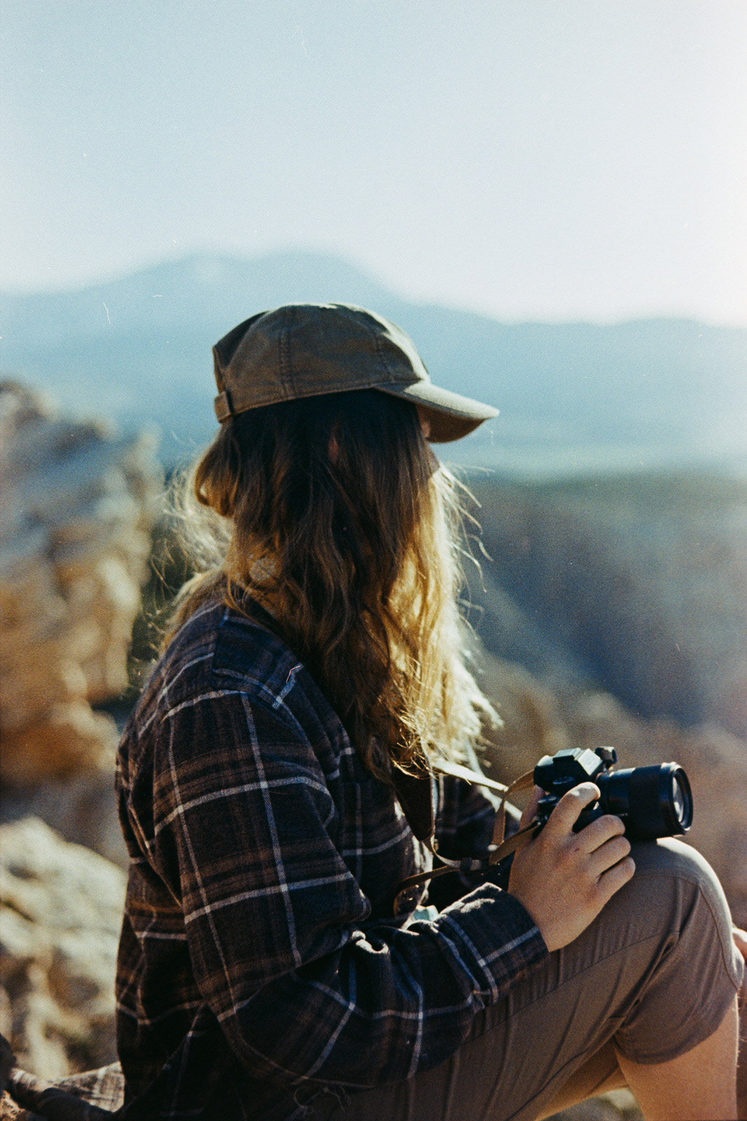 backlit portrait of a woman with a camera overlooking a canyon